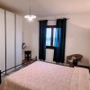 Camera con letto matrimoniale, armadio e finestra con tende scure.