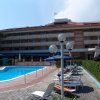 Piscina con sedie a sdraio davanti a un hotel.