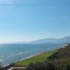 Vista panoramica su mare e montagne sotto un cielo azzurro.