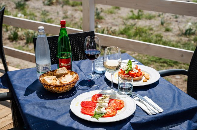 Tavola imbandita con insalate e bevande.