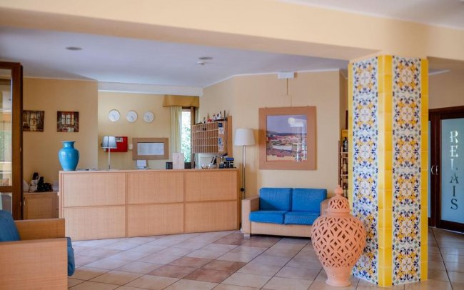 Reception con divano blu e decorazioni colorate.