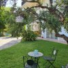 Piccolo tavolino e sedie in ferro battuto sotto un albero con lanterne appese.