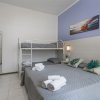 Camera con letto matrimoniale, letto a castello, lenzuola grigie e quadro sopra il letto.