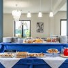 Buffet per la colazione con torte, succhi e cibi vari. Decorazioni alle pareti e lampade sospese.