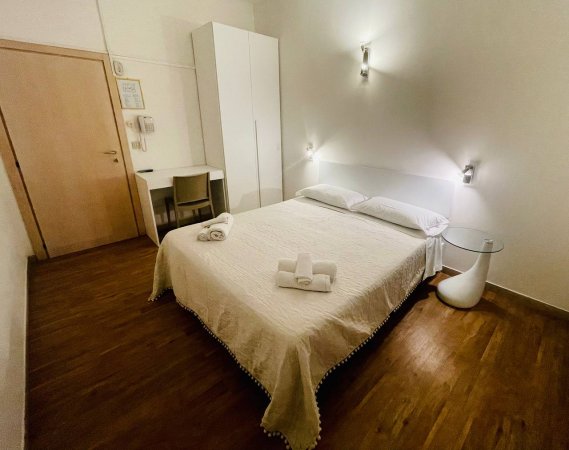 Camera con letto matrimoniale e tavolo.