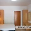 Camera con letto, armadi e tavolo in legno.