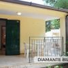 Una terrazza con tavolo e sedie bianche.