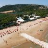 Spiaggia con ombrelloni arancioni e mare calmo.