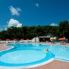 Piscina con ombrelloni arancioni e lettini.