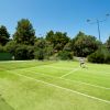 Persone che giocano a tennis su un campo erboso.