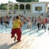Lezione di fitness all'aperto con numerosi partecipanti.