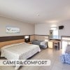 Camera d'albergo con due letti e scrittoio.