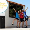 Tre persone felici davanti a un edificio con un grande altoparlante.