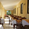 Veranda di un ristorante con tavoli apparecchiati, illuminata dalla luce naturale.