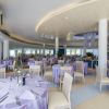 Ristorante elegante con tavoli apparecchiati in tovaglie viola.