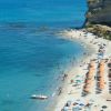 Spiaggia affollata con ombrelloni e bagnanti.