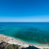 Spiaggia con ombrelloni e mare turchese.