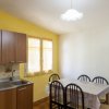 Cucina con tavolo, sedie nere e pareti gialle.