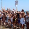 Folla di persone in costume da bagno sulla spiaggia.