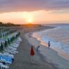 Spiaggia con lettini e ombrelloni al tramonto.