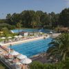 Piscina all'aperto con ombrelloni e lettini.