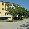Edificio giallo con balconi su un'area pedonale.