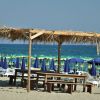 Una spiaggia con ombrelloni e un gazebo di paglia.