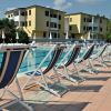 Lettini a bordo piscina con edifici sullo sfondo.