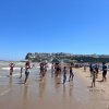 Persone in spiaggia partecipano ad attività.