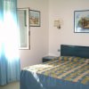Camera da letto con tende blu e quadri alle pareti.
