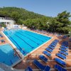 Ampia piscina circondata da lettini blu.
