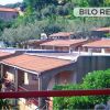 Vista su villette con tetti rossi e vegetazione.