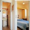 Vista di una camera da letto e un bagno con lavabo.