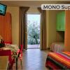 Monolocale con letto colorato e balcone.