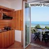 Cucina accanto a balcone con vista mare.