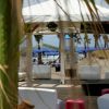 Una gazebo sulla spiaggia con divanetti bianchi e palme.