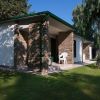 Una casa con pareti in pietra circondata da alberi e prato verde.