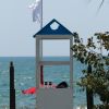 Torretta bianca e blu su passerella in spiaggia.