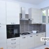 Cucina moderna con mobili chiari e forno.