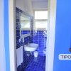 Bagno con piastrelle blu e lavandino bianco.