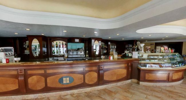 Un bancone bar in legno con specchi e mensole.