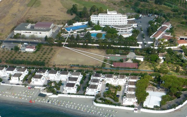 Resort dall'alto con piscine e villette sulla spiaggia.