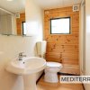 Bagno con lavandino e wc, legno alle pareti.
