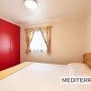 Camera da letto con pareti chiare e armadio rosso.