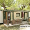 Bungalow con veranda e sedie di plastica all'esterno.