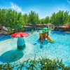 Piscina per bambini con scivolo e fungo rosso.