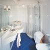 Bagno con doccia, lavabo doppio e piastrelle blu.