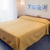 Letto matrimoniale con copriletto giallo e decorazioni.