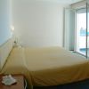 Camera da letto con letto giallo e balcone aperto.