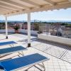 Terrazza con lettini blu e vista panoramica della città.